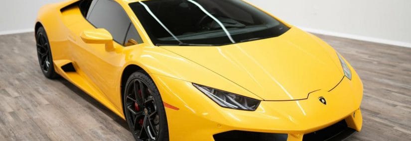 Close-up of a yellow sports car's front with sleek headlights and aerodynamic design.