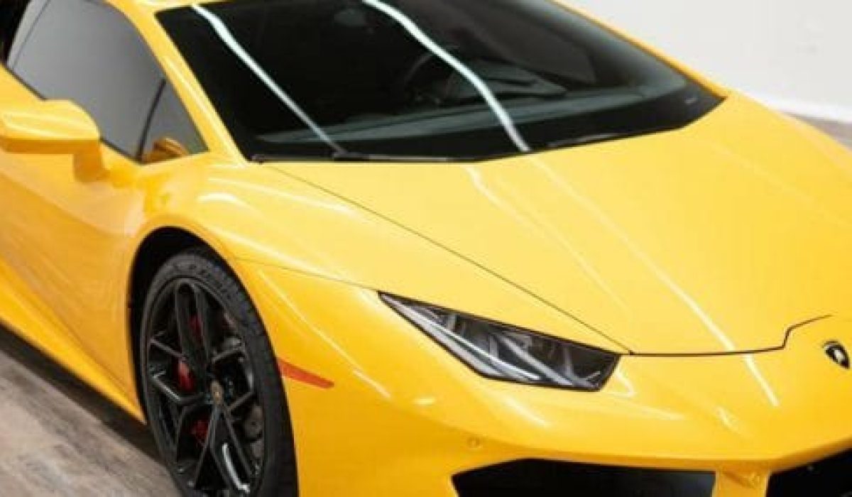 Close-up of a yellow sports car's front with sleek headlights and aerodynamic design.